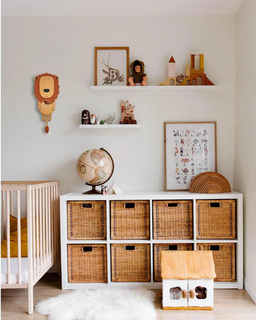 Kids room with a lion wall clock, wicker storage, crib, and decorative toys